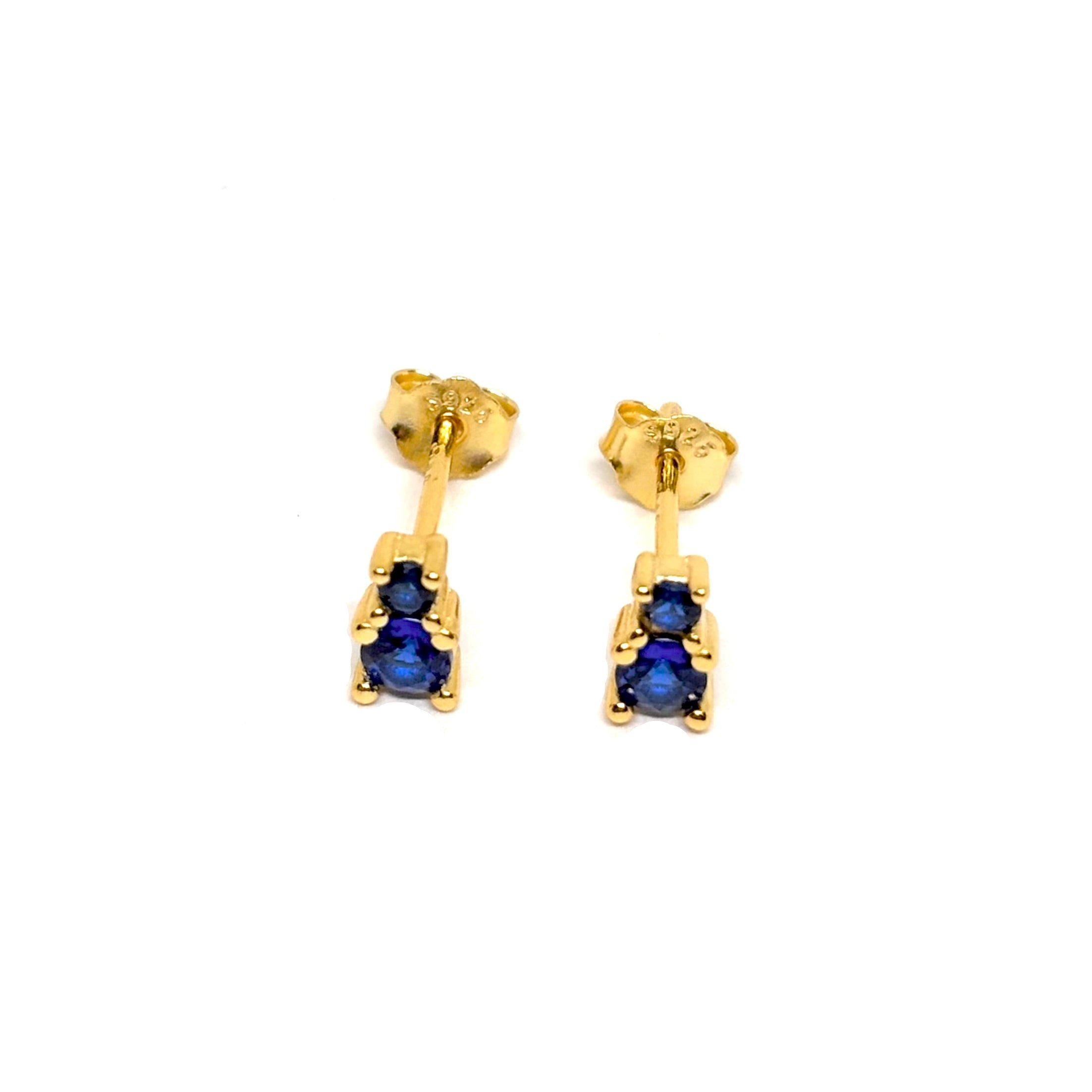 Boucles d’oreilles clous en argent 925 doré à l'or 18k, ornées de zircons bleu saphir éclatants. Bijou sophistiqué et moderne, parfait pour ajouter un éclat subtil et un raffinement à votre look. Ces puces avec zircons bleu saphir, idéales pour des occasions spéciales ou un usage quotidien, offrent une finition durable et brillante, tout en apportant une touche de luxe et de couleur à votre style. Discrètes mais élégantes, elles conservent leur brillance au fil du temps et sont parfaites pour un look chic e